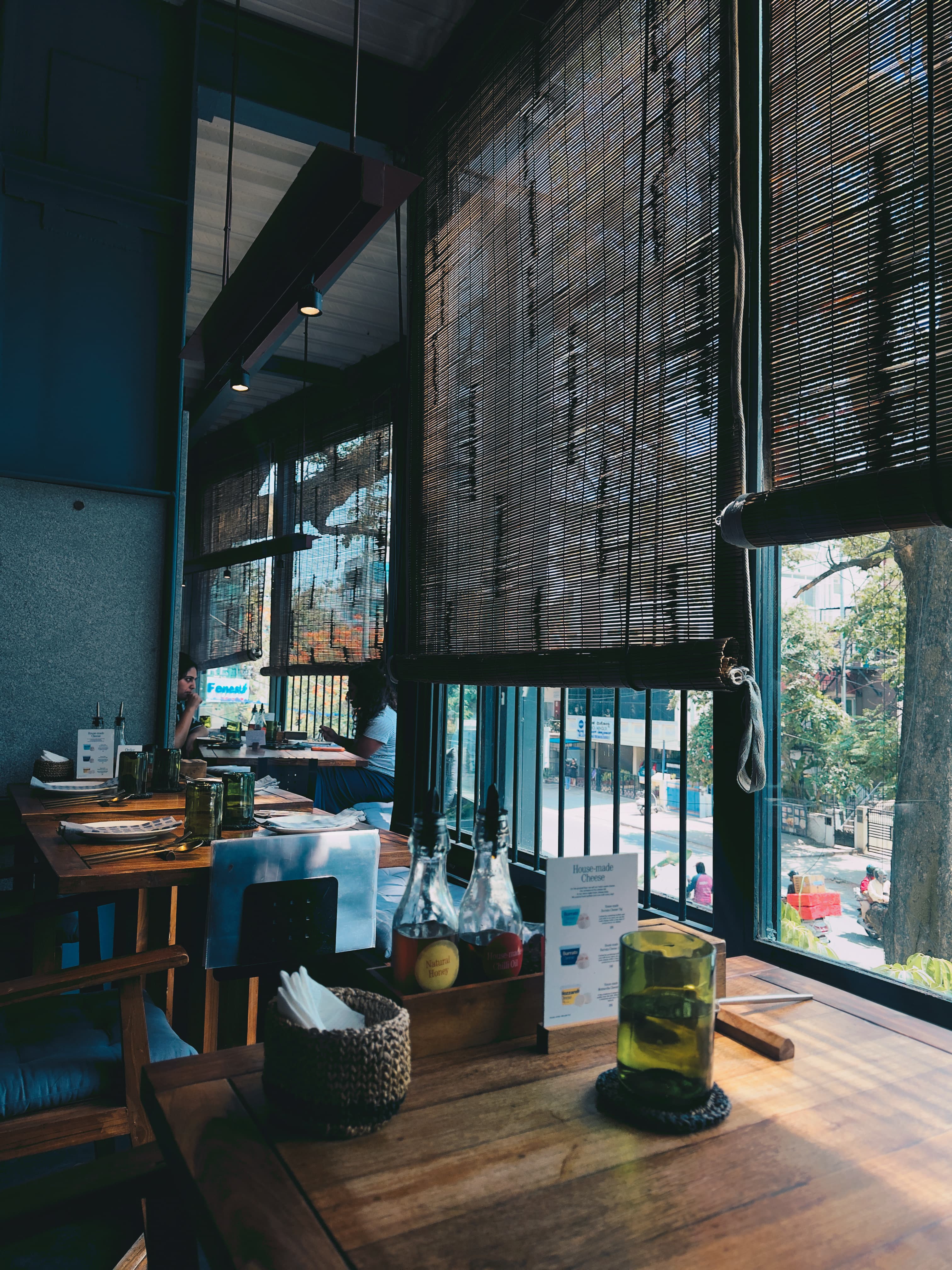 Cafe interior with bamboo blinds, wooden tables, and warm ambient light